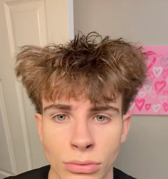 Maverick Clark holding a cologne bottle in his room